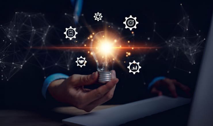 Un hombre de negocios sostiene una bombilla y una computadora portátil