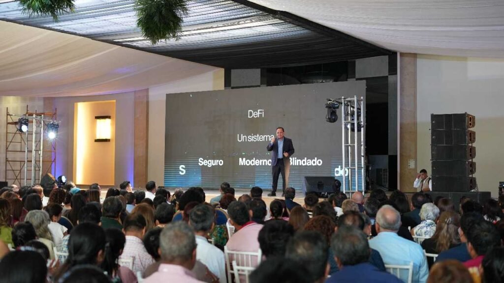 Ernesto Reséndiz frente a un grupo de personas escuchando
