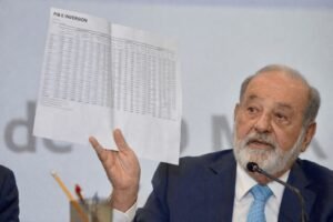 : Carlos Slim durante una conferencia de prensa mostrando un documento